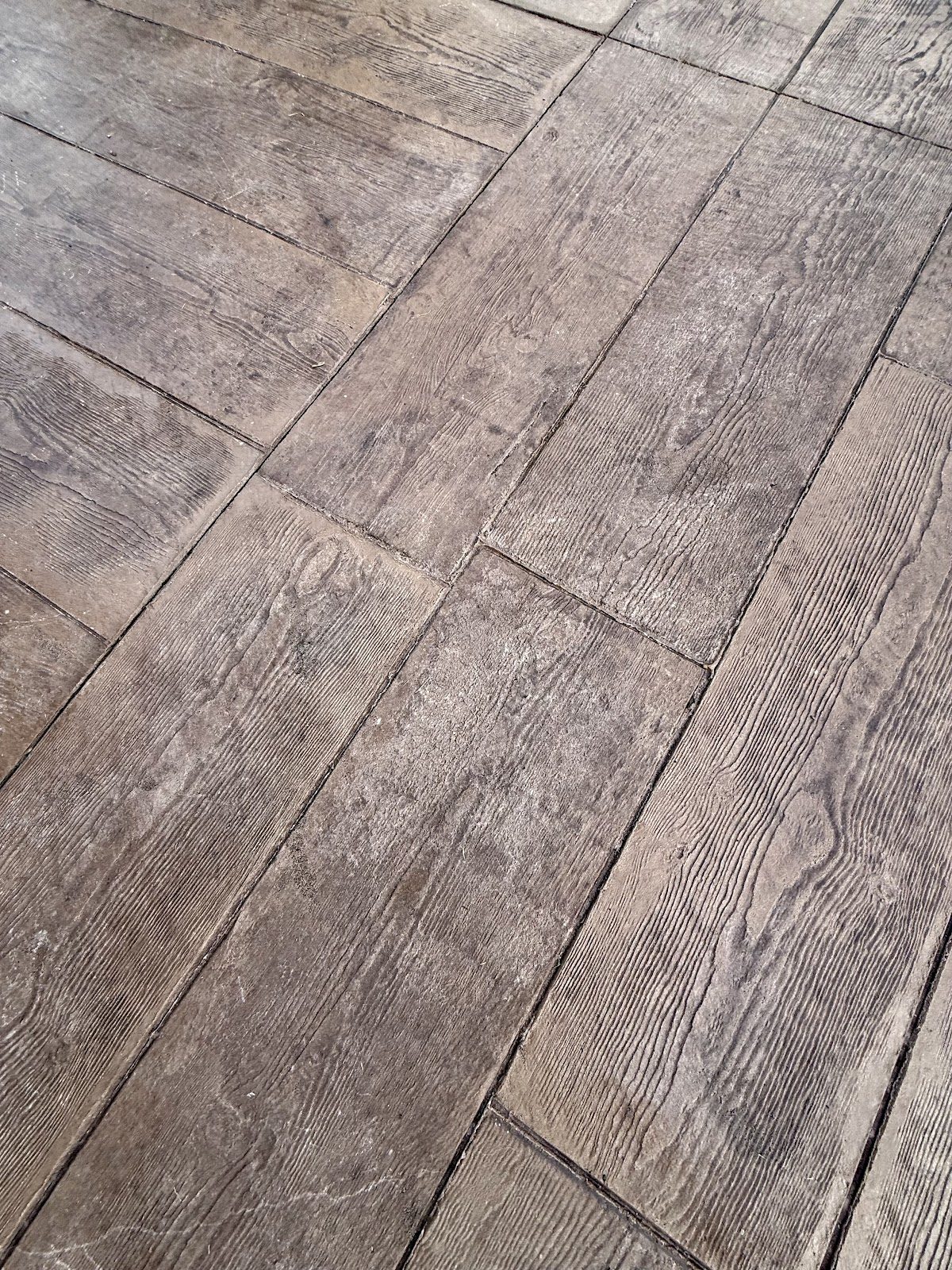 Close detail of wood-plank stamped concrete showing grain texture and plank joints